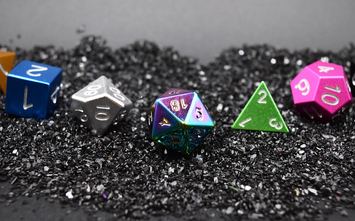 The seven Casters dice laid out on black grit.