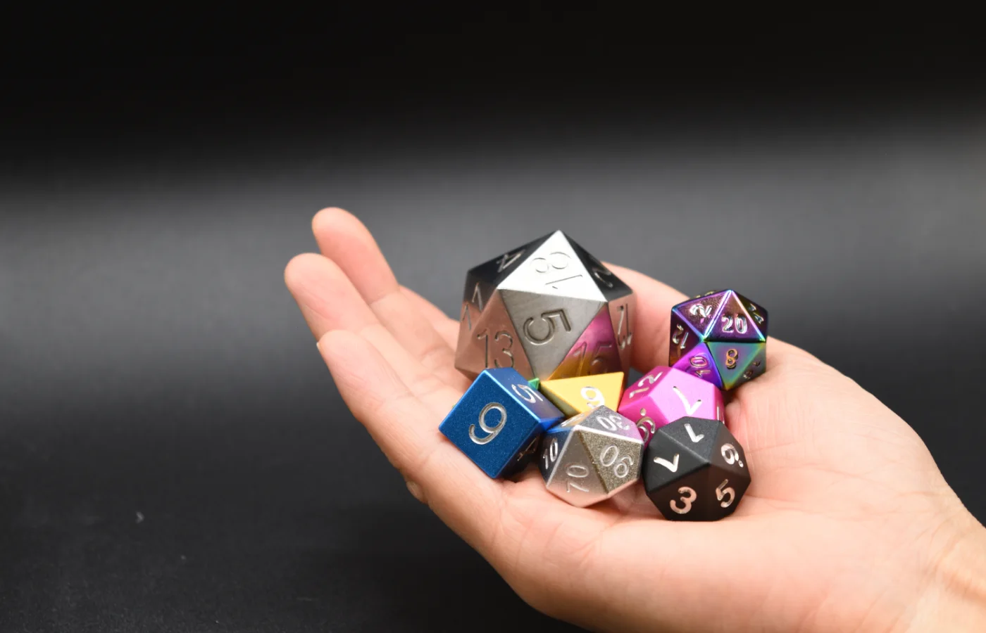 A full set of Pantheon dice held in an open hand.